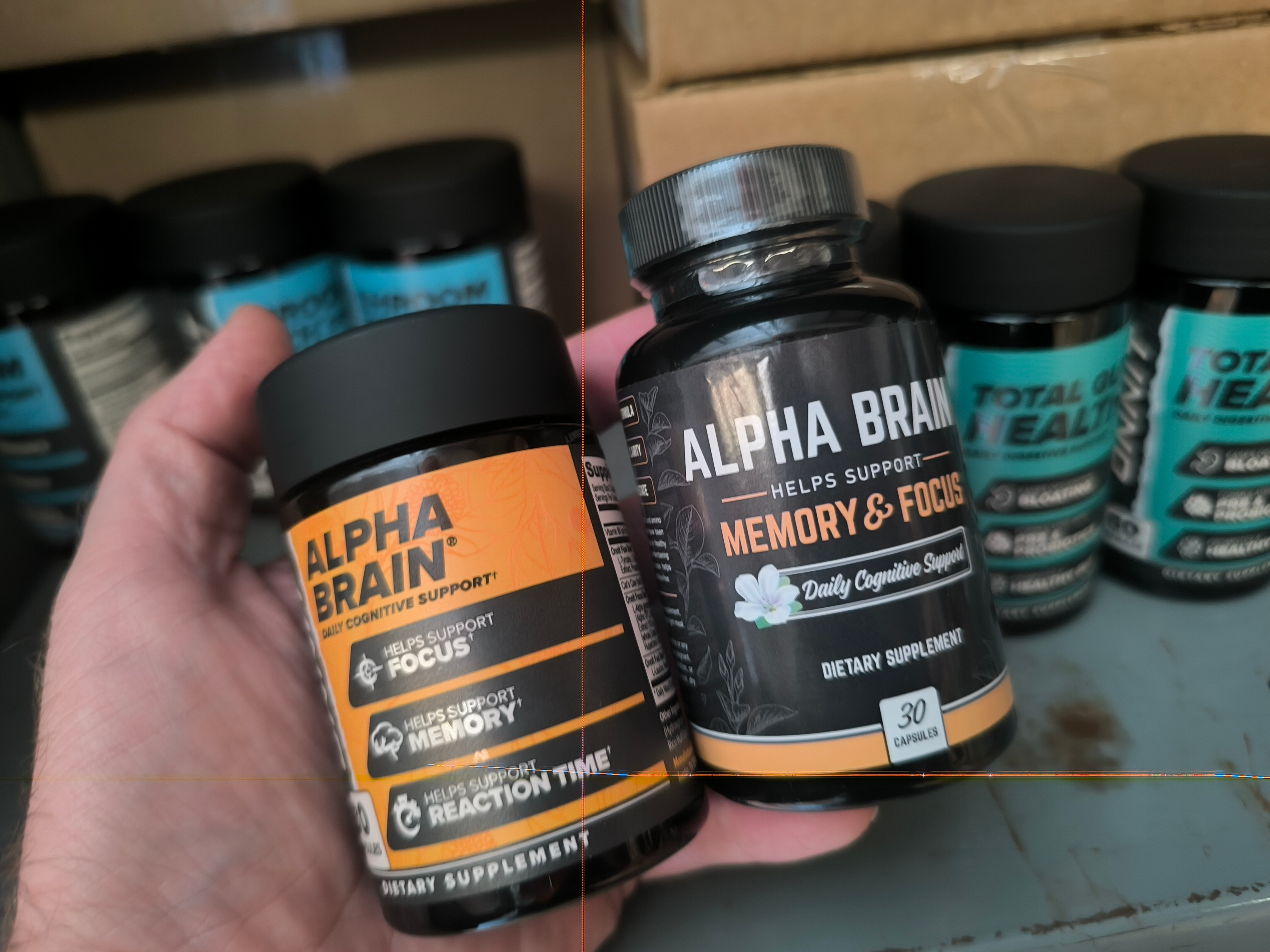 A genuine bottle of alpha brain beside a counterfeit bottle of alpha brain